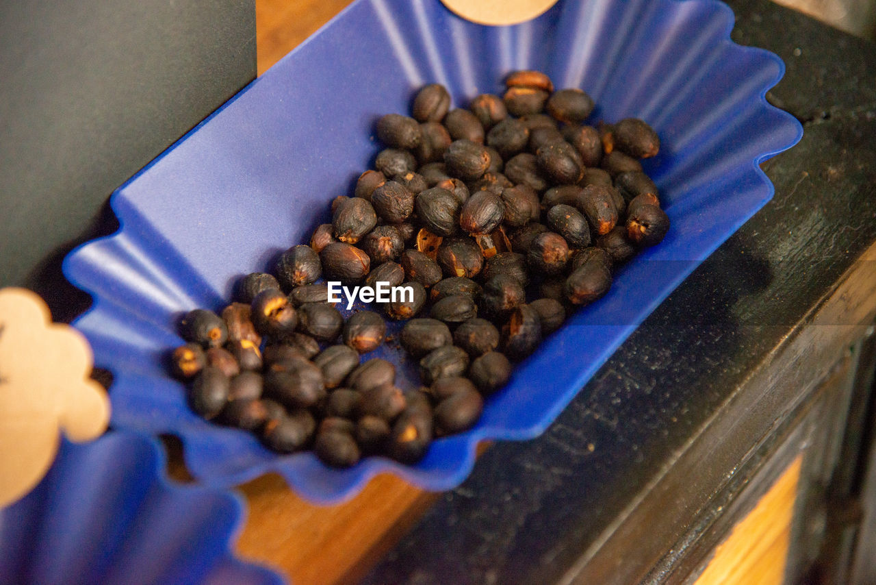 HIGH ANGLE VIEW OF ROASTED COFFEE BEANS IN CONTAINER