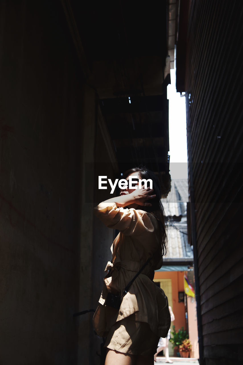 YOUNG WOMAN LOOKING AT BUILDING