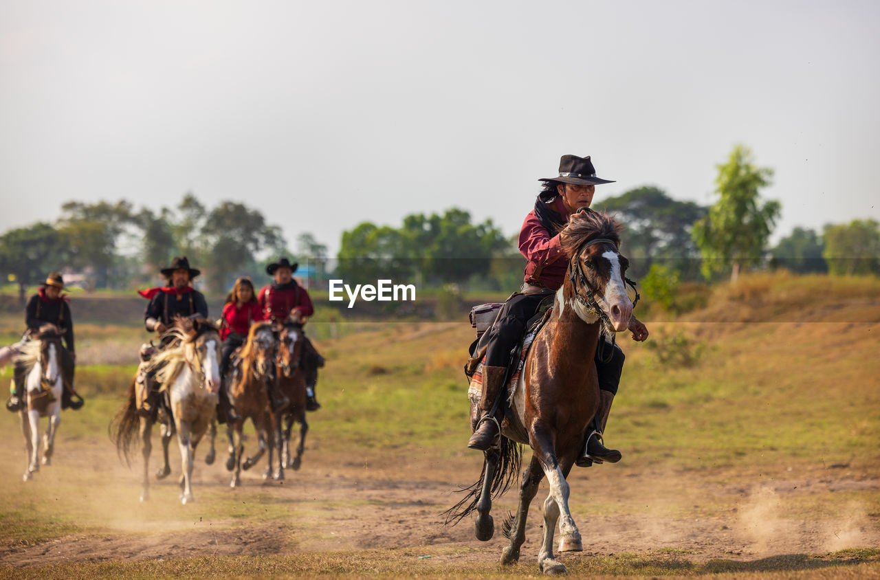 Cowboy's way of life include riding a horse around locales.