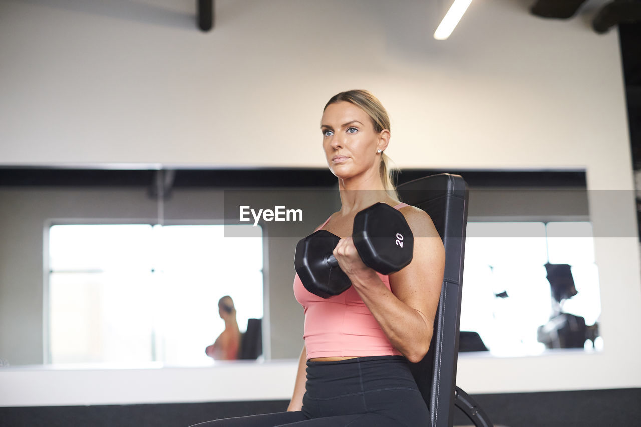 A woman lifting weights in a fitness studio