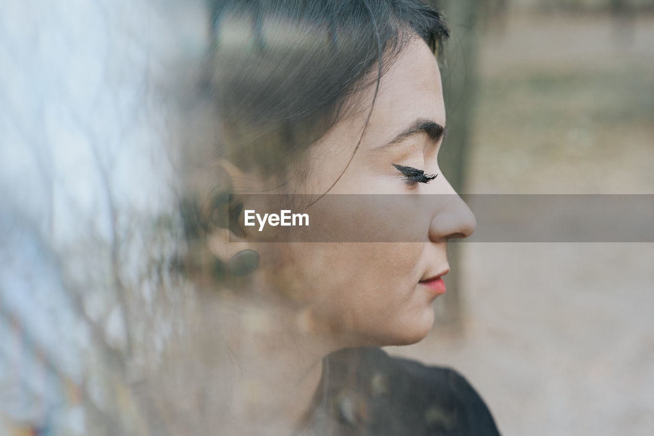 Close-up of young woman with eyes closed outdoors