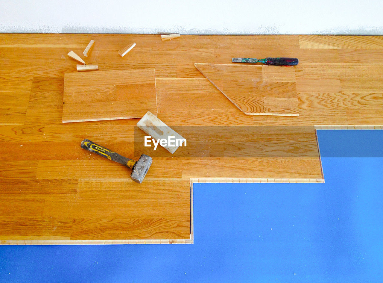 wood, indoors, floor, no people, diy, work tool, blue, high angle view, table, flooring, wood stain, hardwood floor, copy space, home improvement