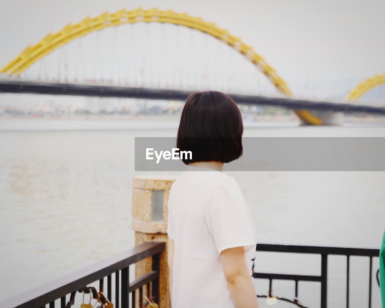 Woman standing by river in city