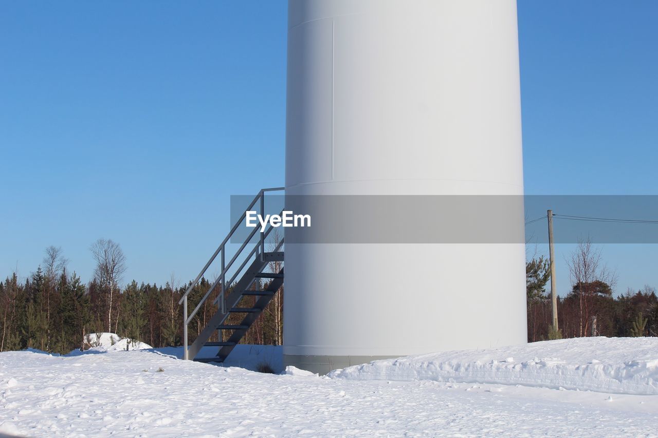 LOW ANGLE VIEW OF SNOW ON FIELD AGAINST CLEAR SKY