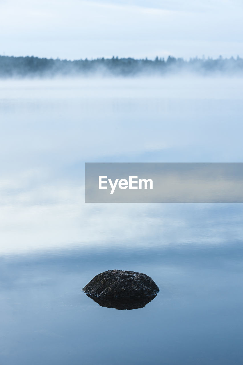 Stone lying in still and misty lake