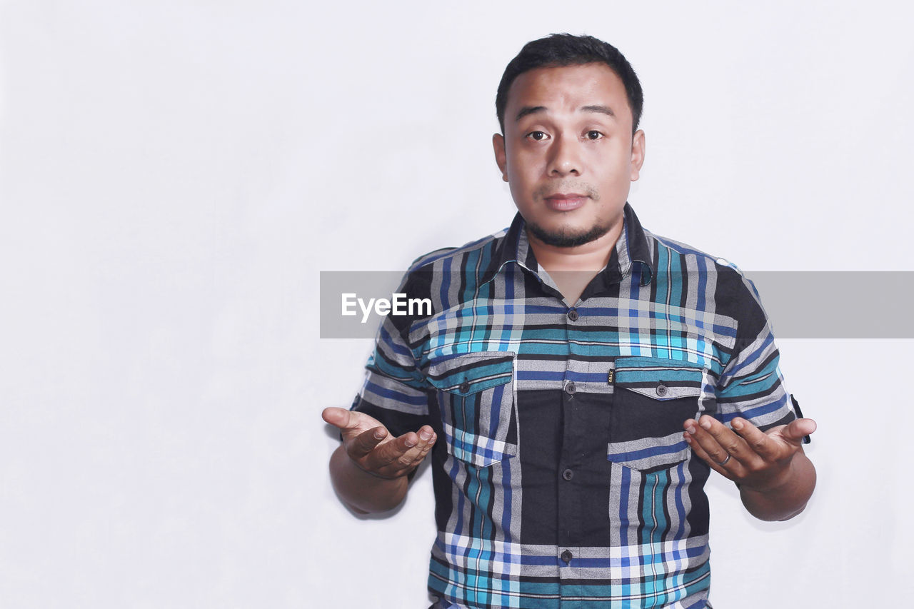 Portrait of man standing against white background