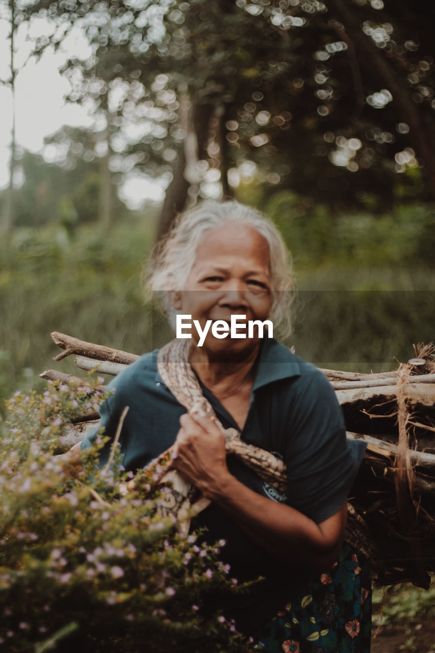 Portrait of old woman standing in forest