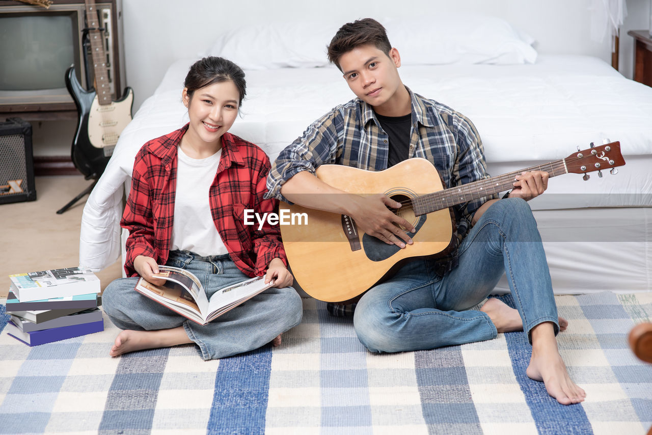 YOUNG MEN PLAYING GUITAR