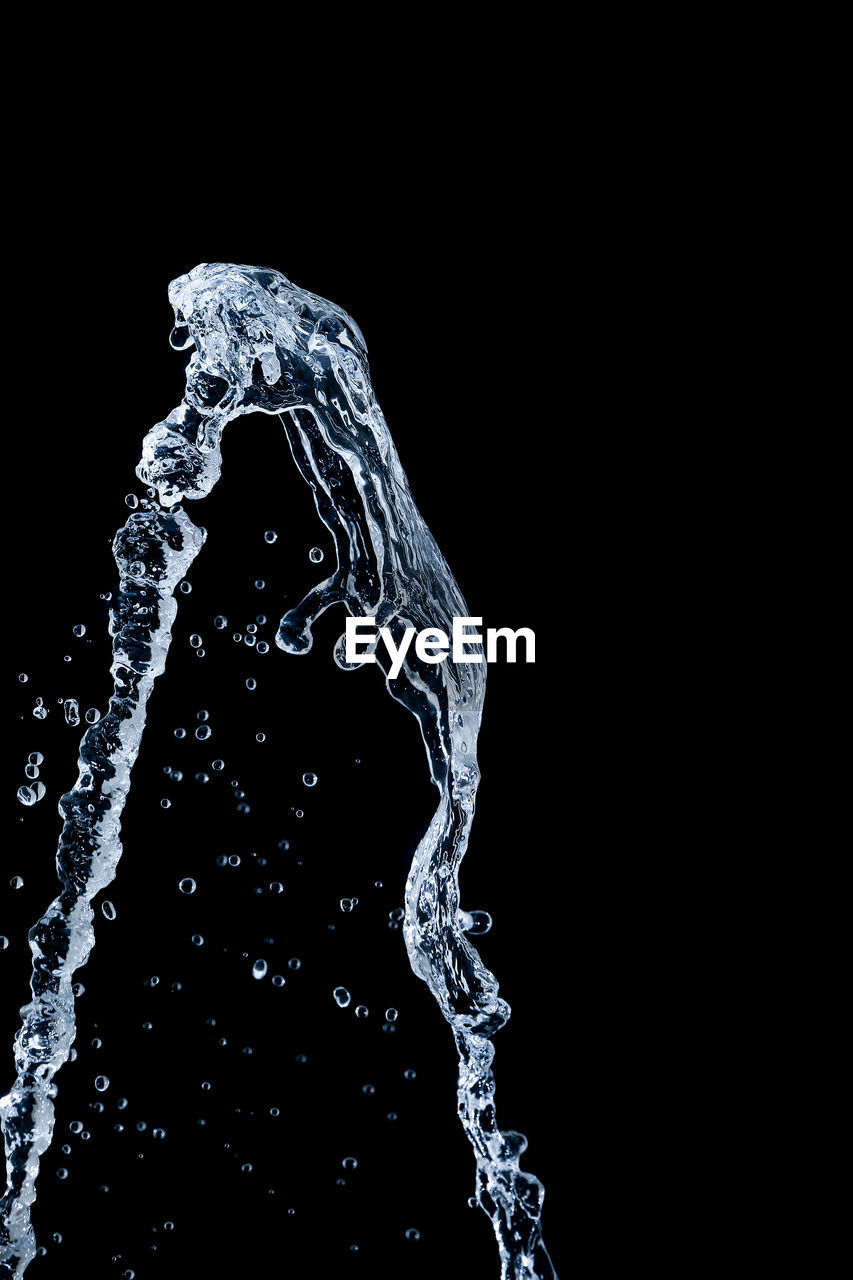 CLOSE-UP OF WATER SPLASHING ON SEA AGAINST BLACK BACKGROUND