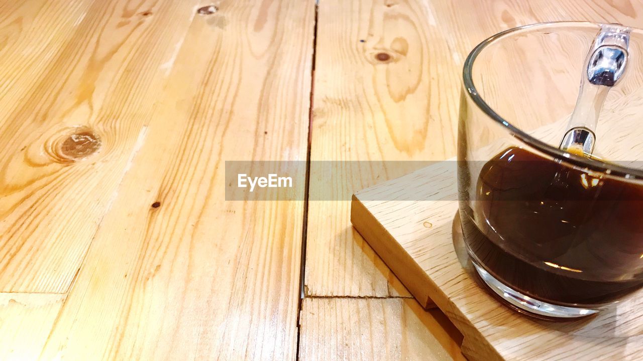 HIGH ANGLE VIEW OF DRINK ON TABLE AT HARDWOOD FLOOR