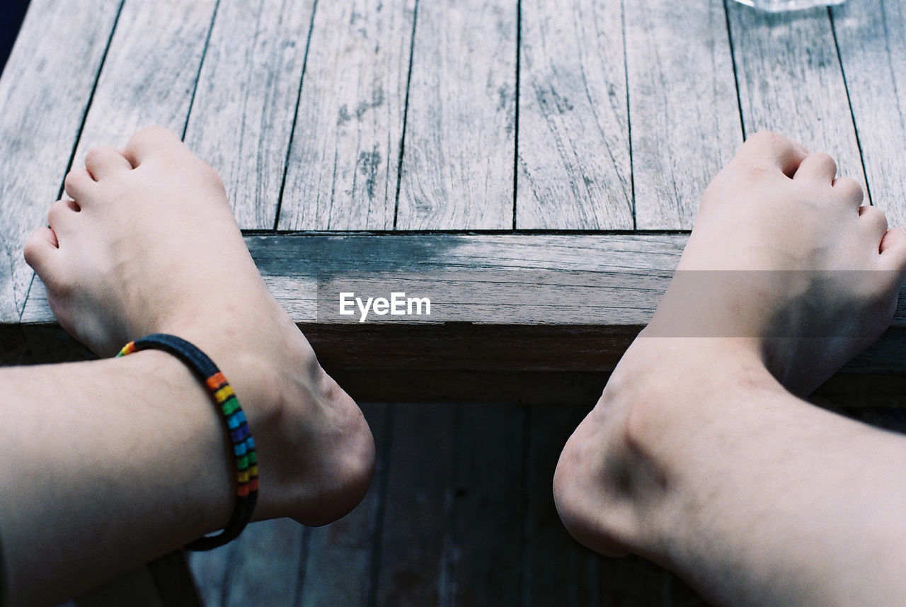 Low section of person on wooden table