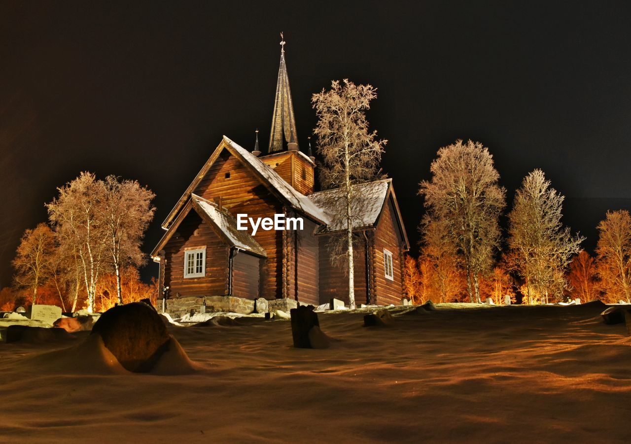 HOUSES BY TREES AGAINST SKY DURING WINTER