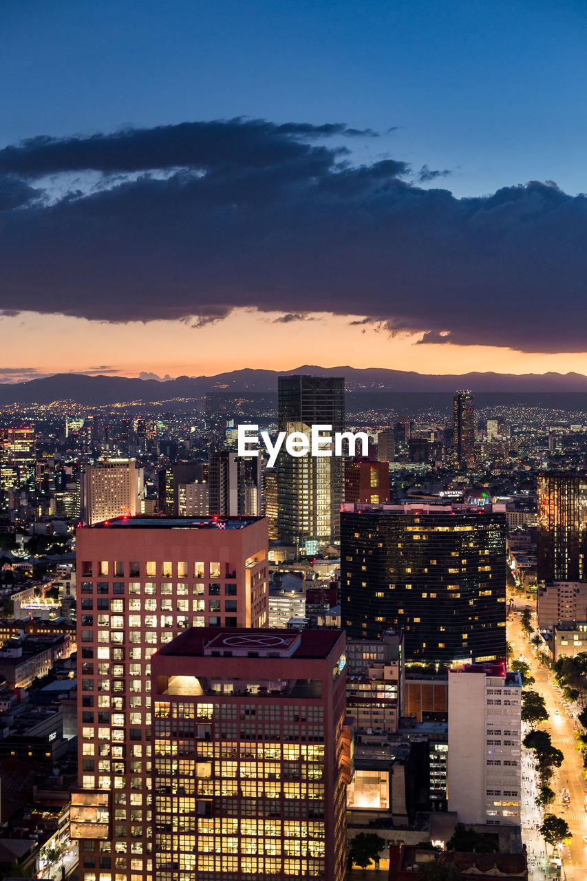 High angle view of illuminated buildings from mexico city during a summer sunset.