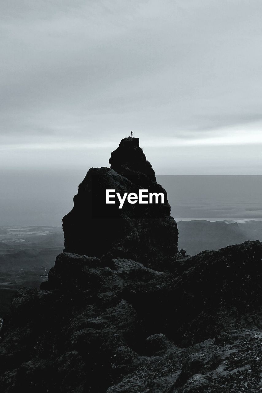 ROCK FORMATION ON SEA AGAINST SKY