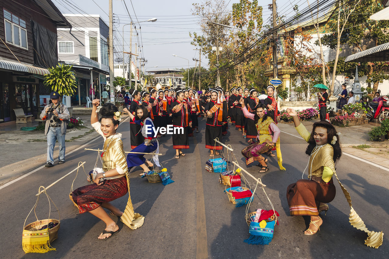 GROUP OF PEOPLE SITTING ON STREET