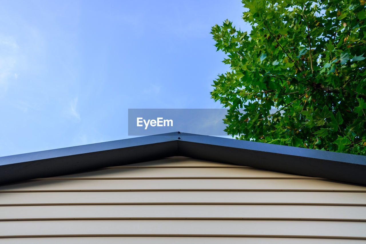 LOW ANGLE VIEW OF BUILDING AND TREES AGAINST SKY