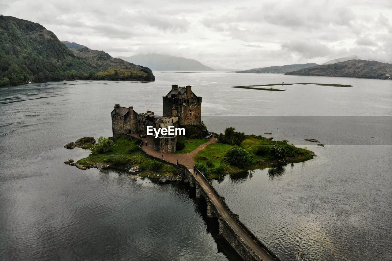 Scenic view of sea by castle against sky