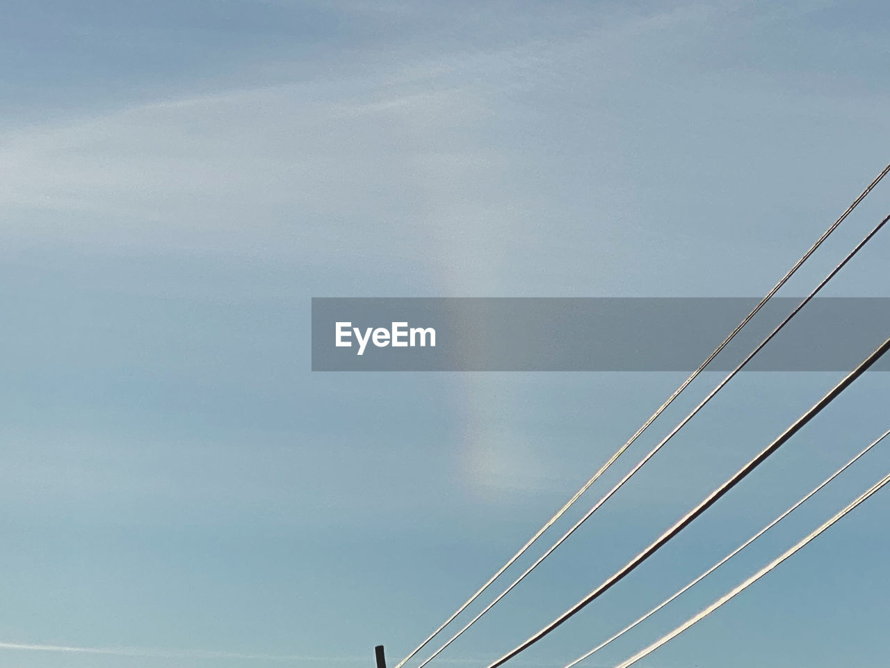 LOW ANGLE VIEW OF CABLES AGAINST RAINBOW IN SKY