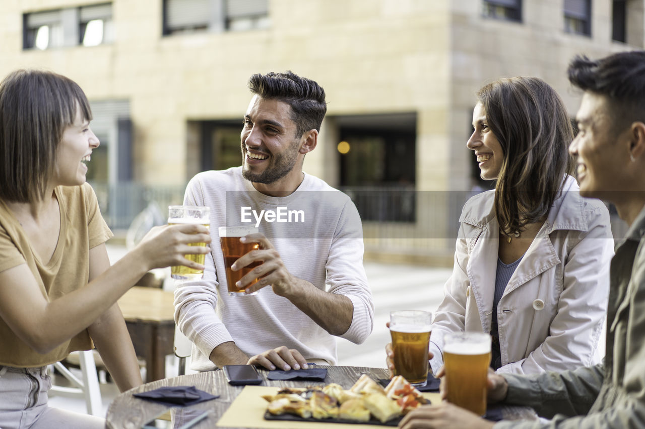 GROUP OF PEOPLE DRINKING GLASS AT TABLE