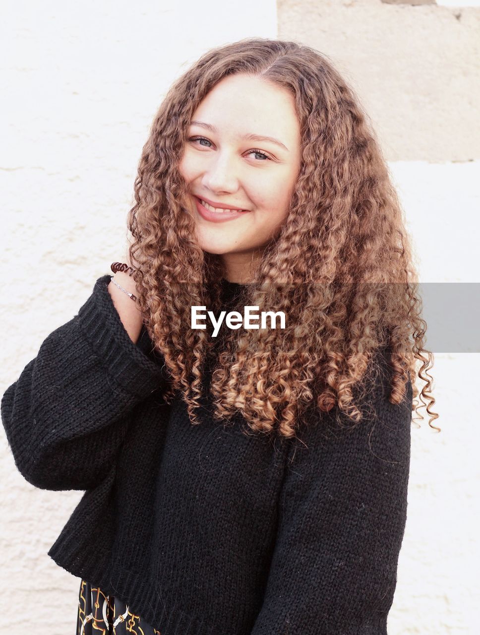 Portrait of smiling young woman with curly hair