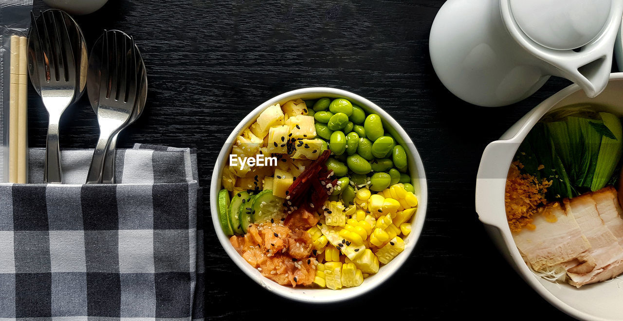 Flat lay of fresh salad on black wooden table