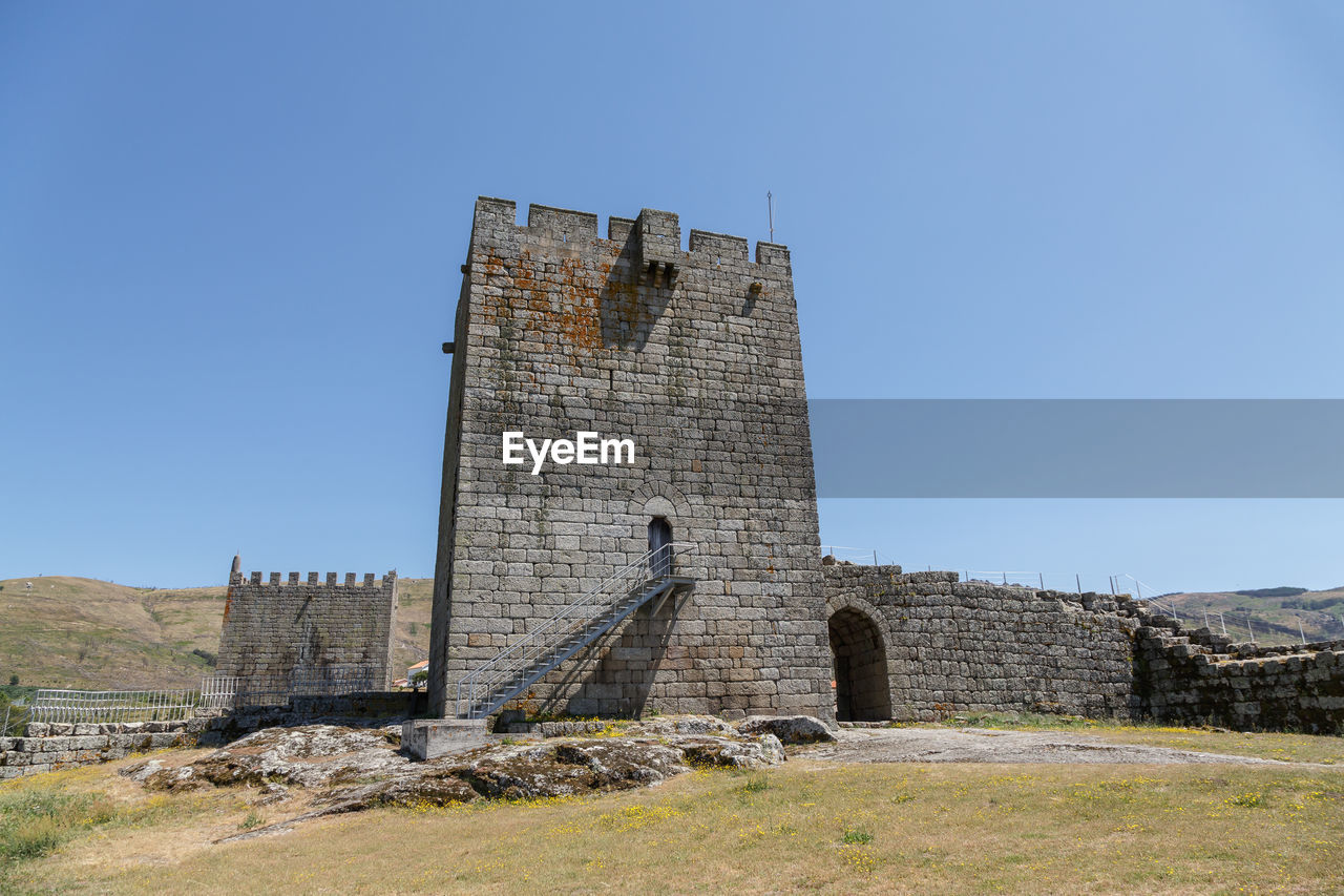 architecture, history, built structure, the past, building, sky, fortification, building exterior, clear sky, ruins, travel destinations, nature, travel, wall, fort, tower, blue, no people, castle, ancient, old ruin, old, sunny, landmark, landscape, tourism, ancient history, day, outdoors, land, medieval, stone material