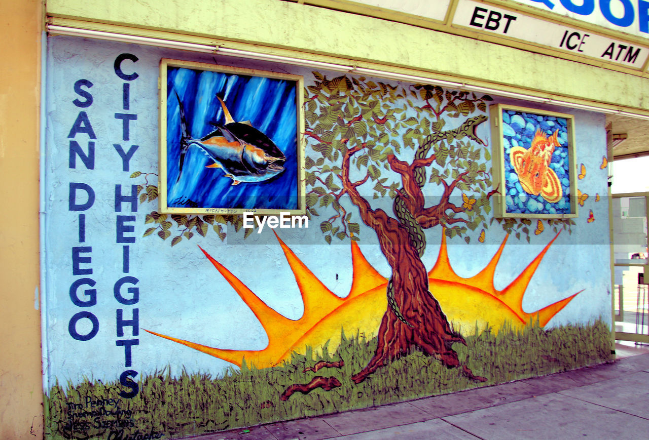 graffiti, architecture, art, text, mural, creativity, communication, no people, representation, painting, street art, day, wall - building feature, built structure, western script, building exterior, human representation, multi colored, wall, sign, cartoon, urban area, outdoors, animal representation, city, paint, male likeness, vandalism