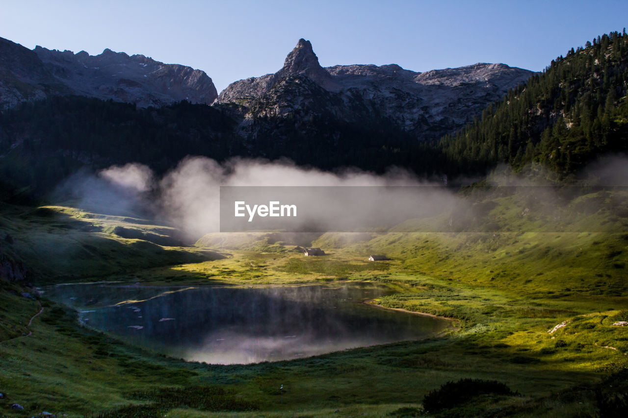 Scenic view of berchtesgaden alps against clear sky in foggy weather