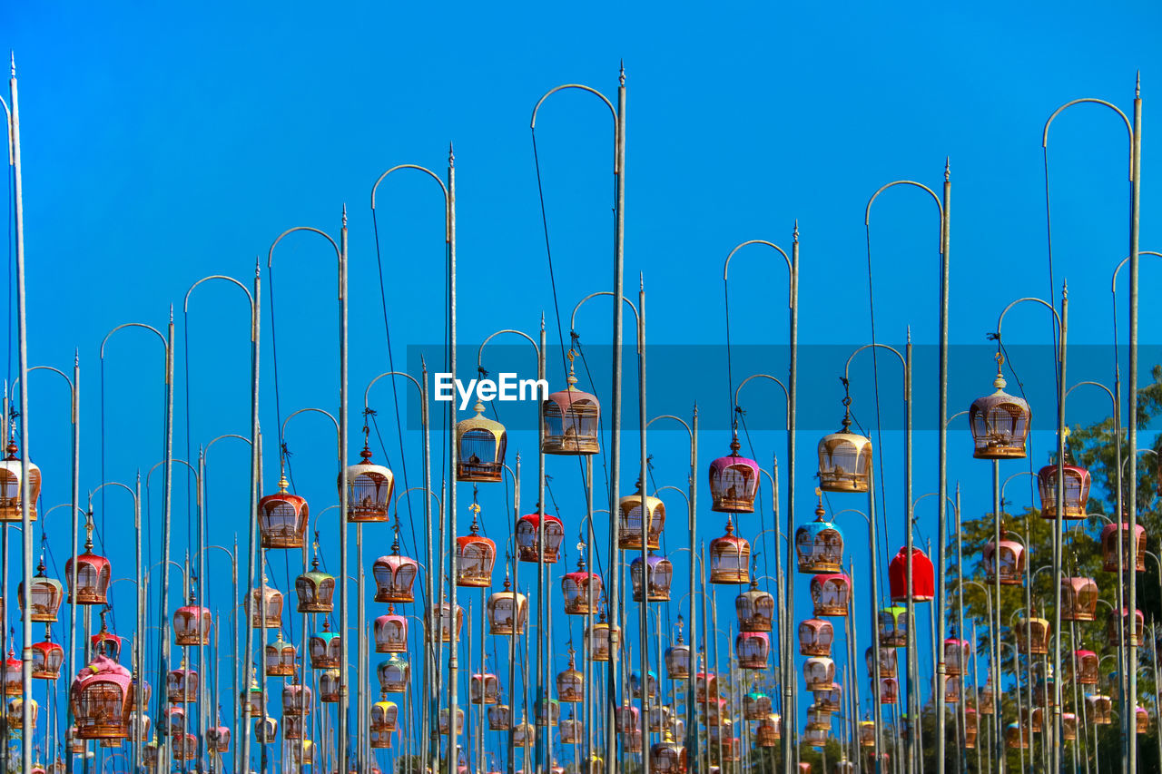 Bird cage hanging on pole against blue sky. contest bird sound tradition in thailand