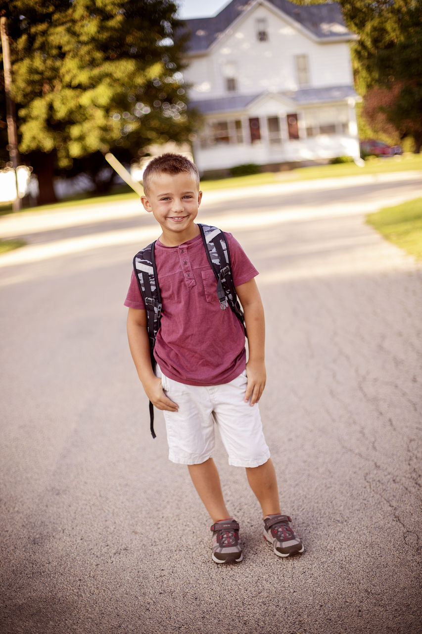 PORTRAIT OF HAPPY BOY ON ROAD