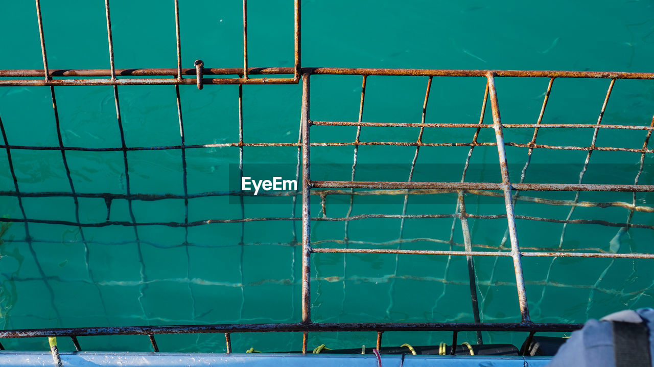 HIGH ANGLE VIEW OF SWIMMING POOL AGAINST SEA