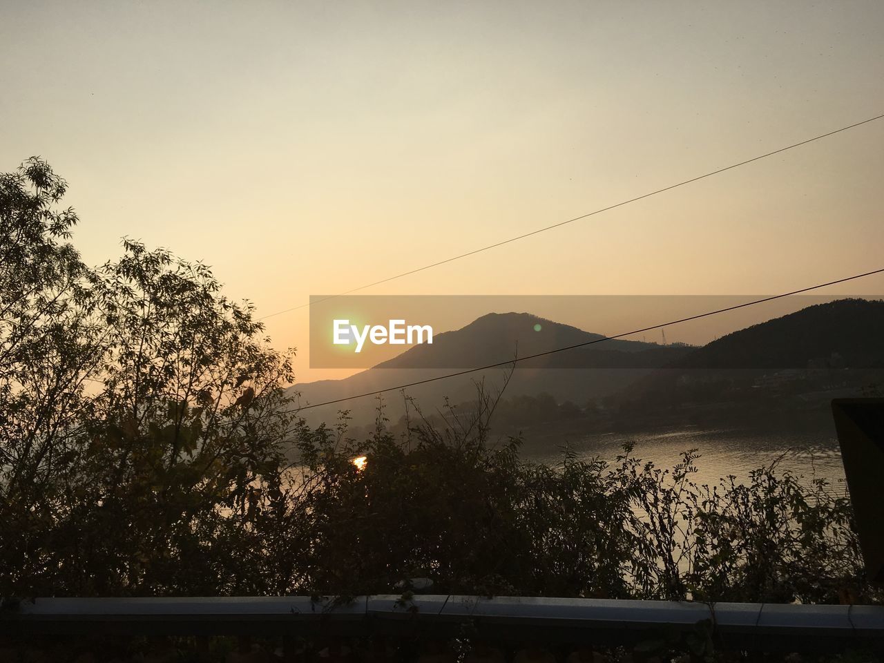 Scenic view of lake and mountains against sky during sunset