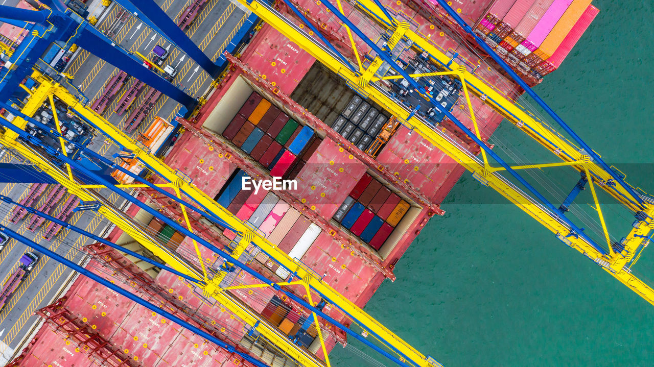 Directly above shot of crane and cargo container by lake