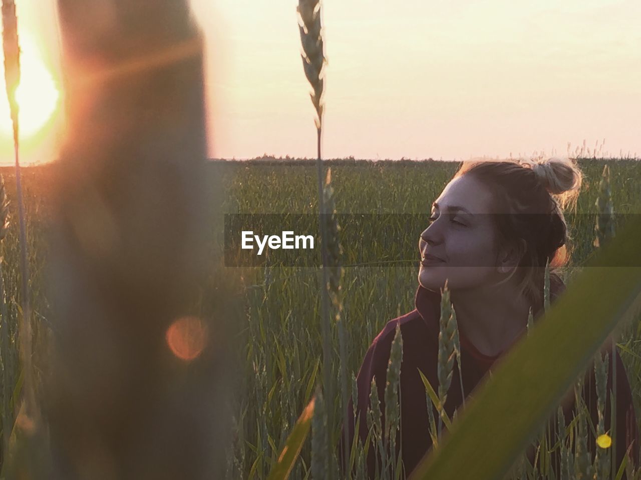 Close-up of young woman on field against sky