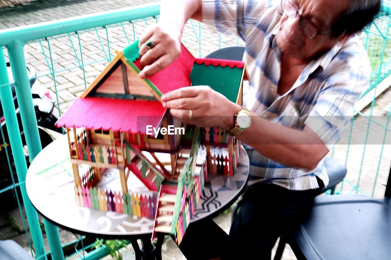 MIDSECTION OF WOMAN PLAYING WITH MULTI COLORED TABLE