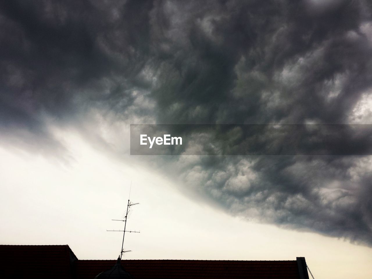 LOW ANGLE VIEW OF SILHOUETTE HOUSE ROOF AGAINST SKY