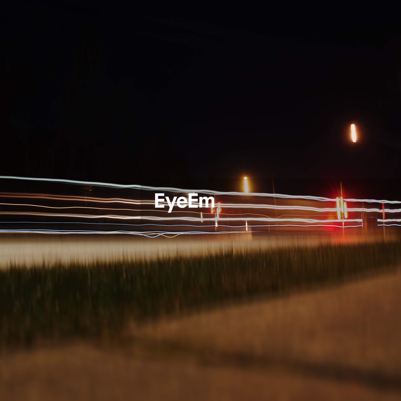 Light trails on road against sky at night