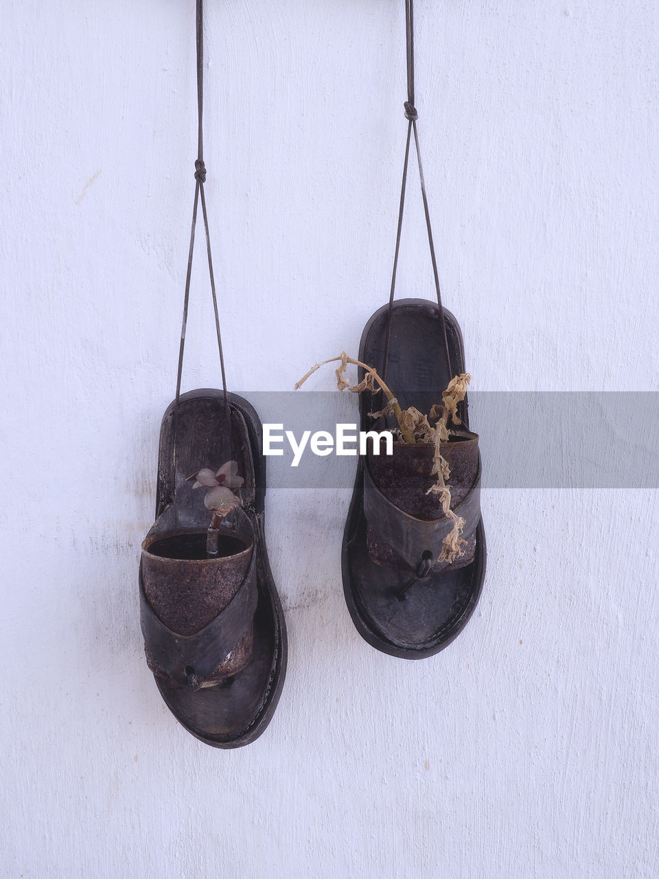 HIGH ANGLE VIEW OF SHOES HANGING ON FLOOR AGAINST WALL