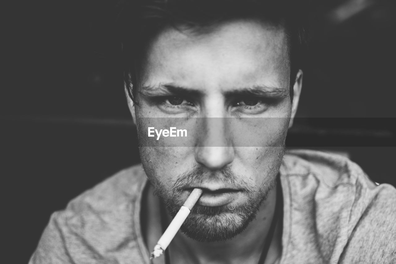 Close-up portrait of man smoking cigarette