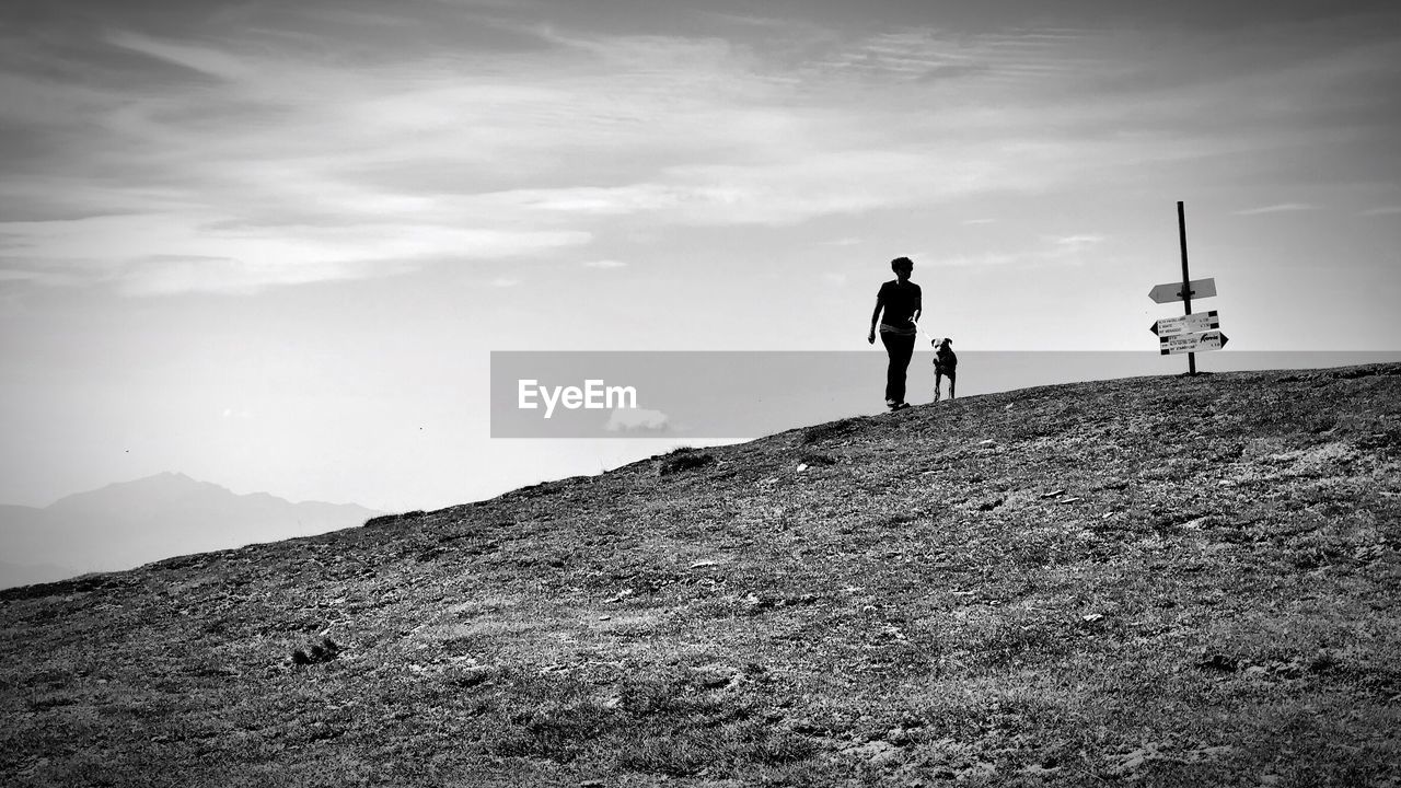 PEOPLE ON MOUNTAIN AGAINST SKY