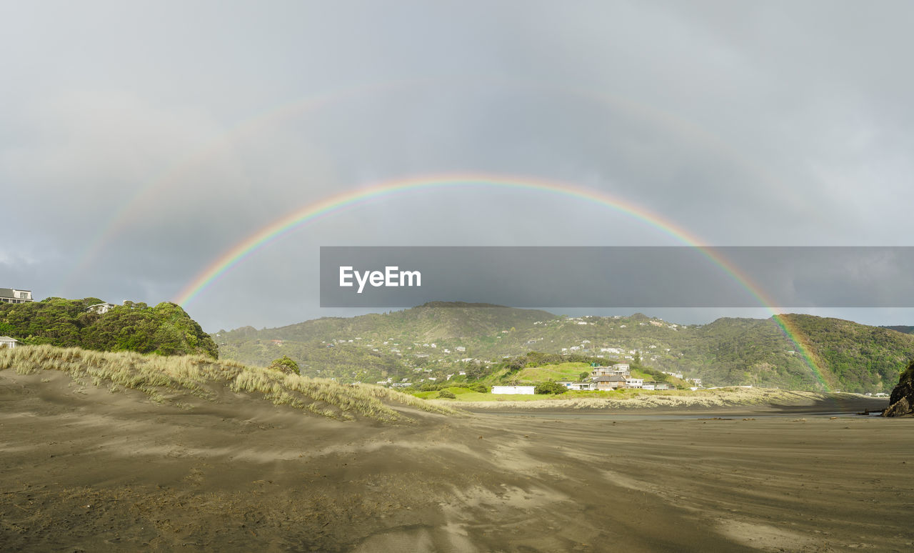 RAINBOW OVER LAND AGAINST SKY