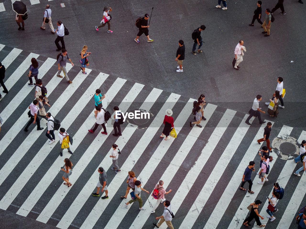 HIGH ANGLE VIEW OF GROUP OF PEOPLE CROSSING ROAD