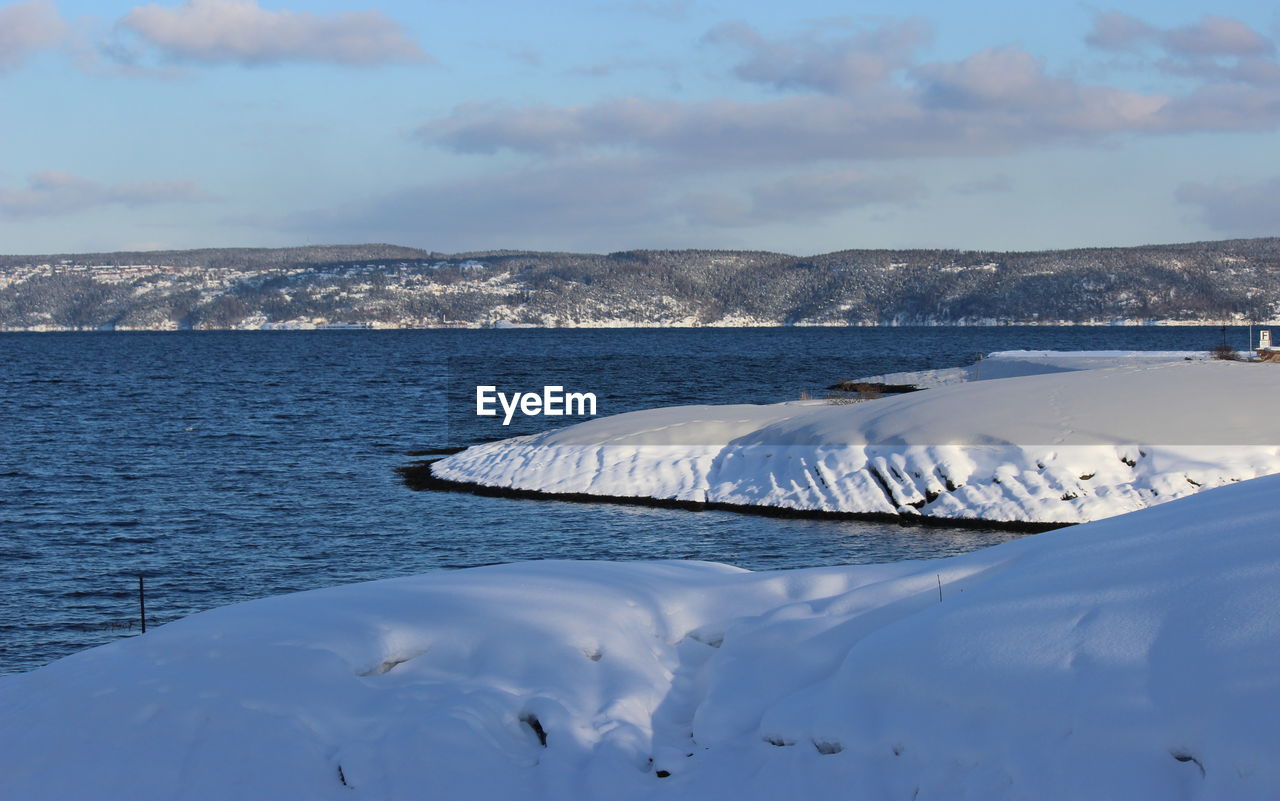 Close-up of ice floating on sea against sky