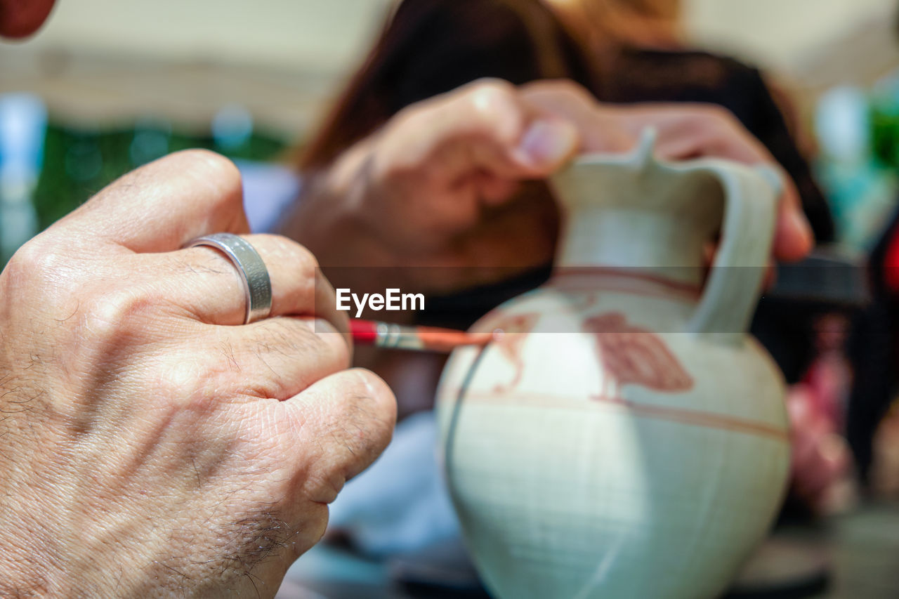 Close-up of woman painting pottery