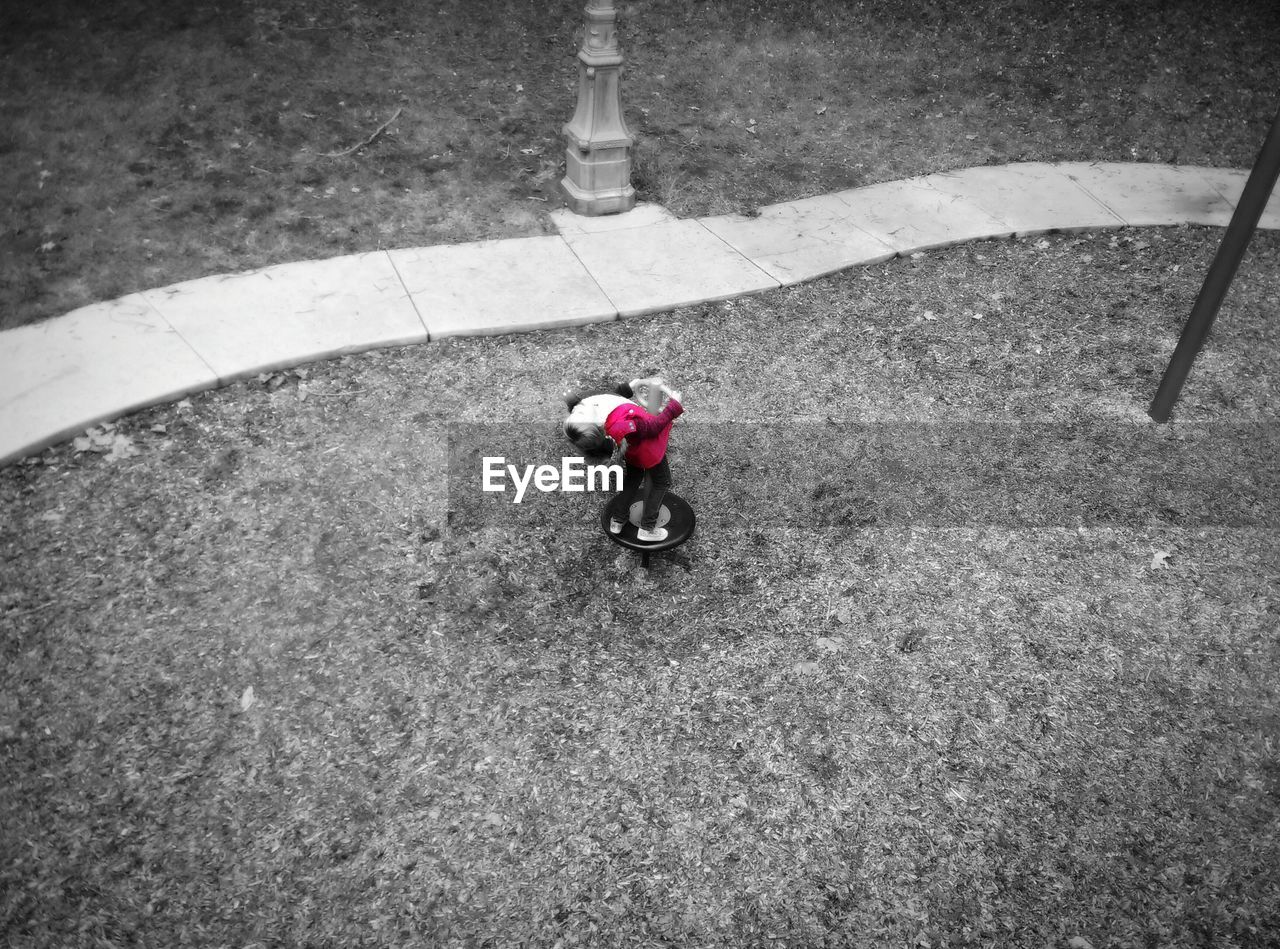 High angle view of girl playing on spring ride at park