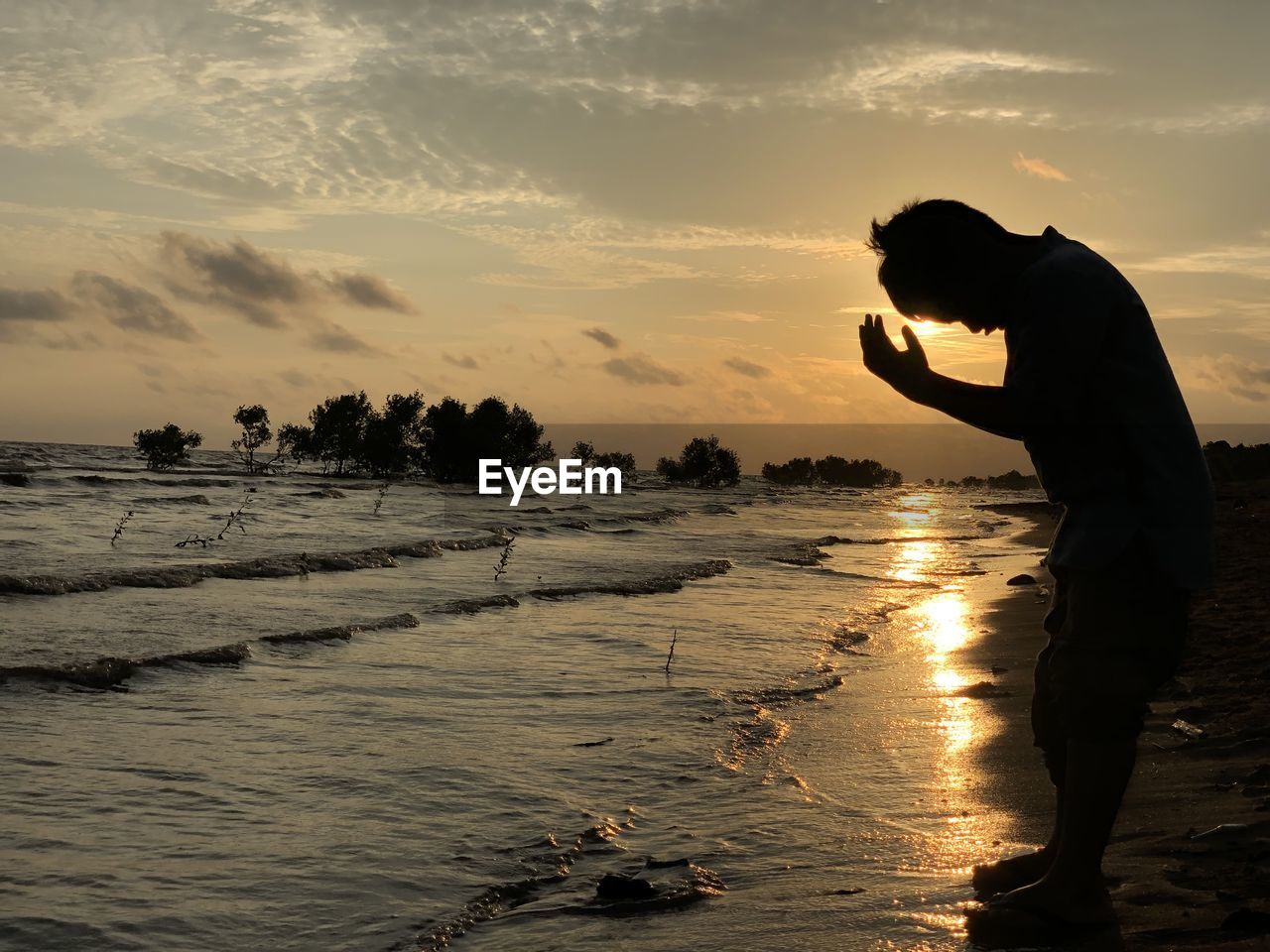 water, sunset, sky, sea, beach, silhouette, land, nature, wave, one person, ocean, evening, sunlight, reflection, horizon, cloud, shore, men, dusk, adult, beauty in nature, coast, sand, standing, occupation, scenics - nature, side view, outdoors, activity, sun, full length, person, leisure activity, lifestyles, tranquility, backlighting