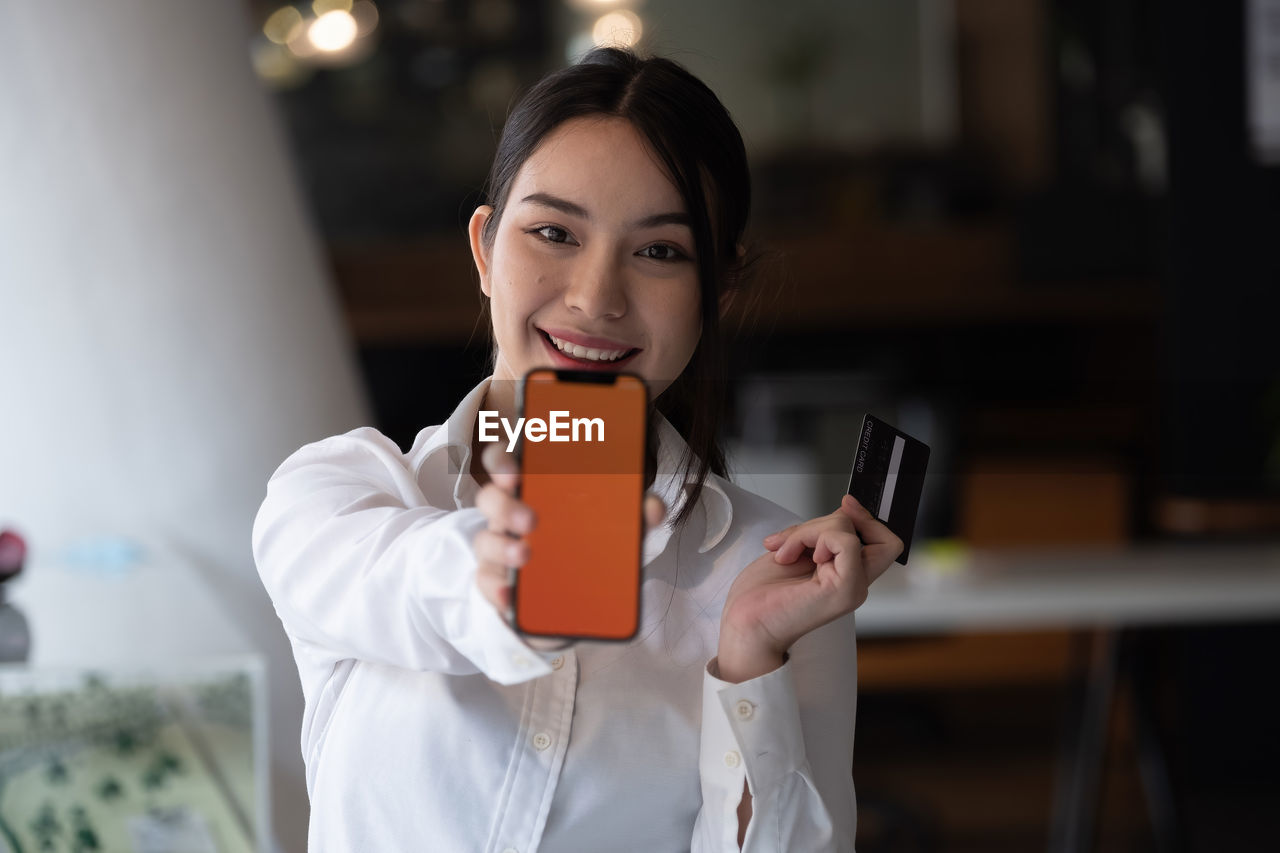 Portrait of woman holding mobile phone