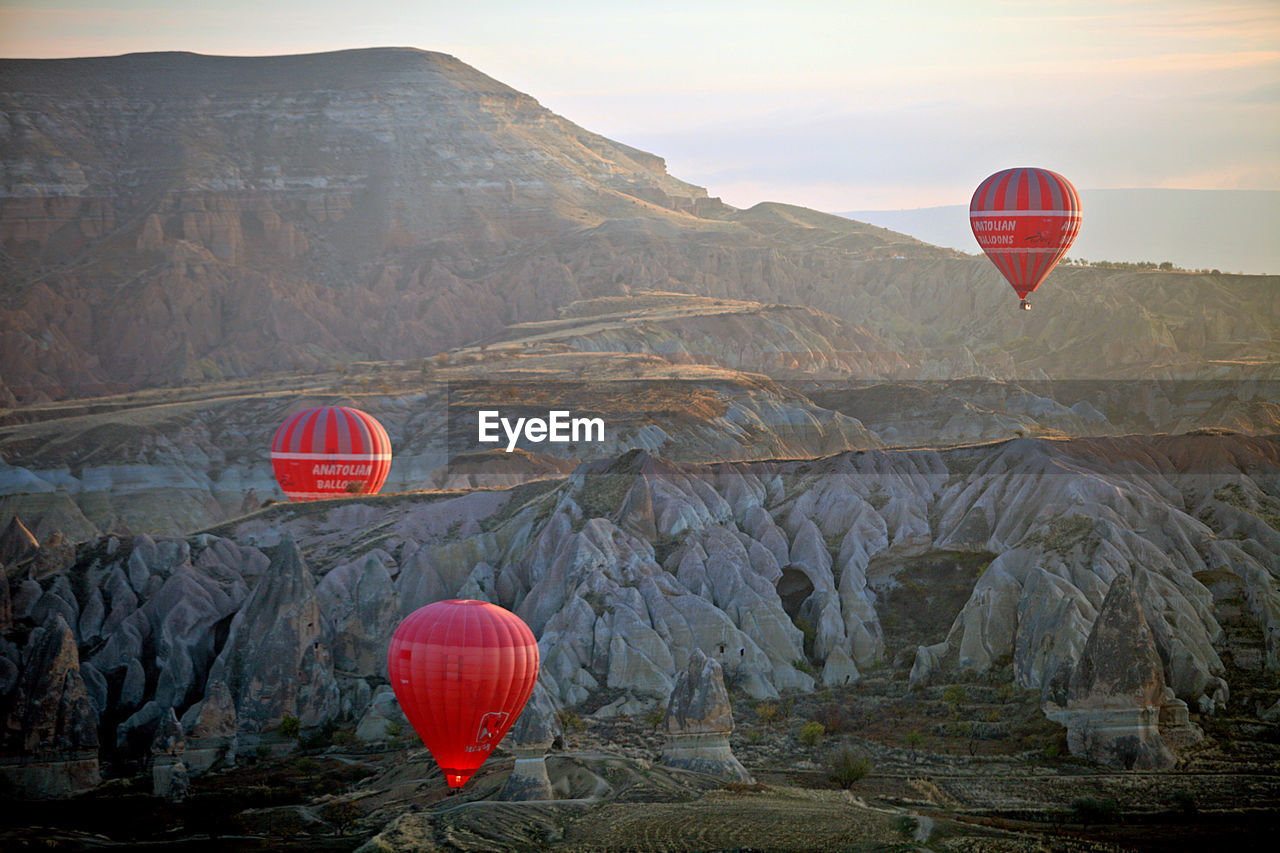 VIEW OF HOT AIR BALLOON FLYING OVER MOUNTAINS