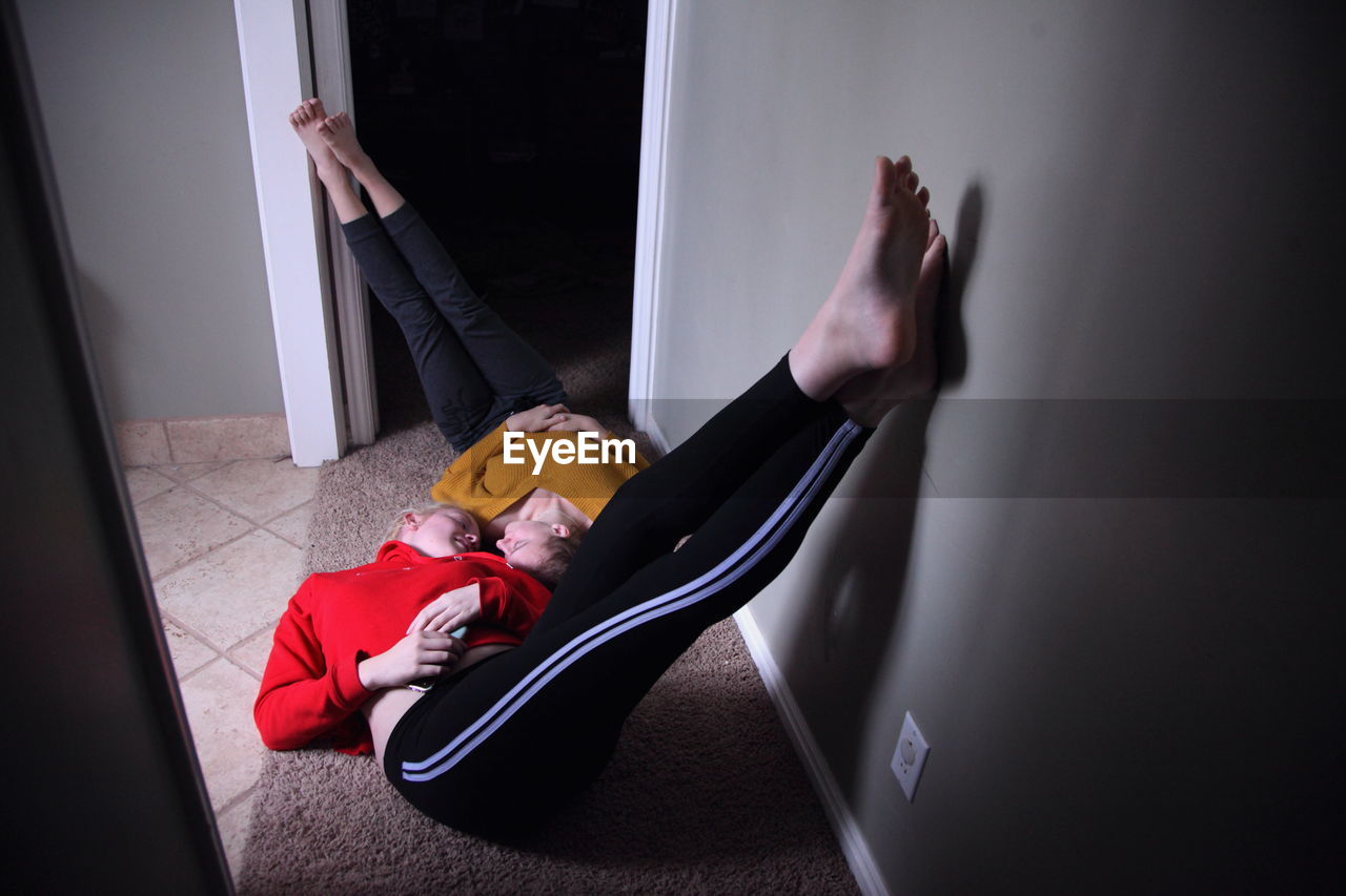 High angle view of young lesbian couple lying on rug at home