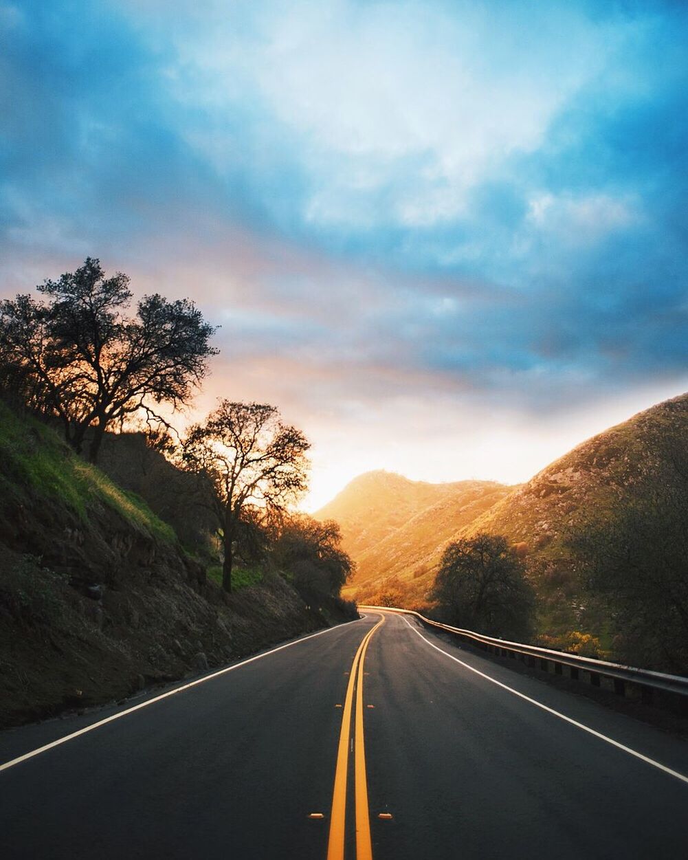 Road amidst mountains against cloudy sky